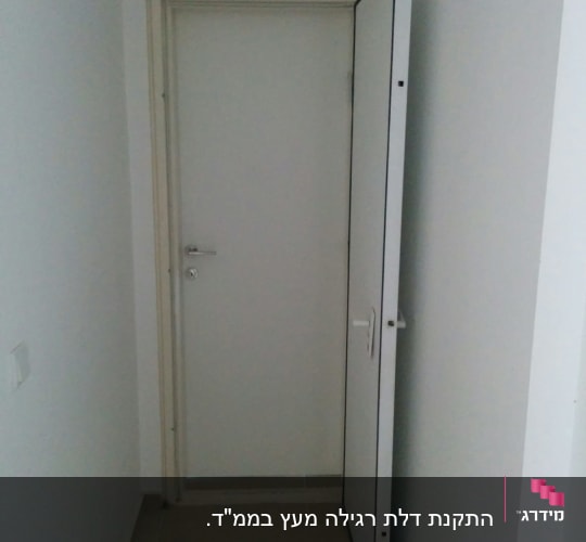 דלת לבנה פתוחה למחצה עם ידית מתכת